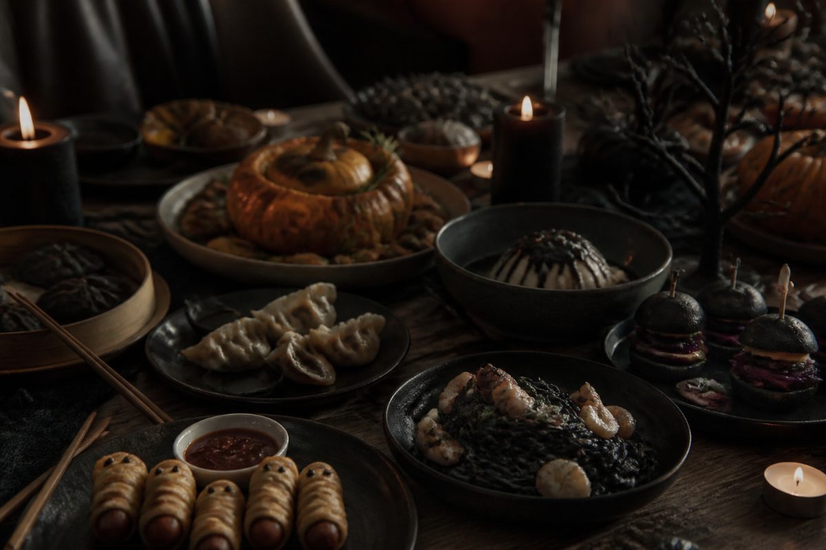 Halloween-middag med internationella rätter vid ett pyntat bord